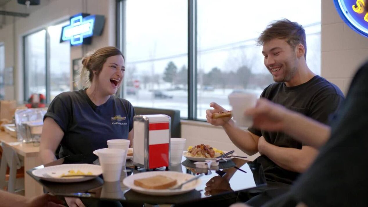 GM Technician Ashley Laughing and Eating Lunch with a Colleague