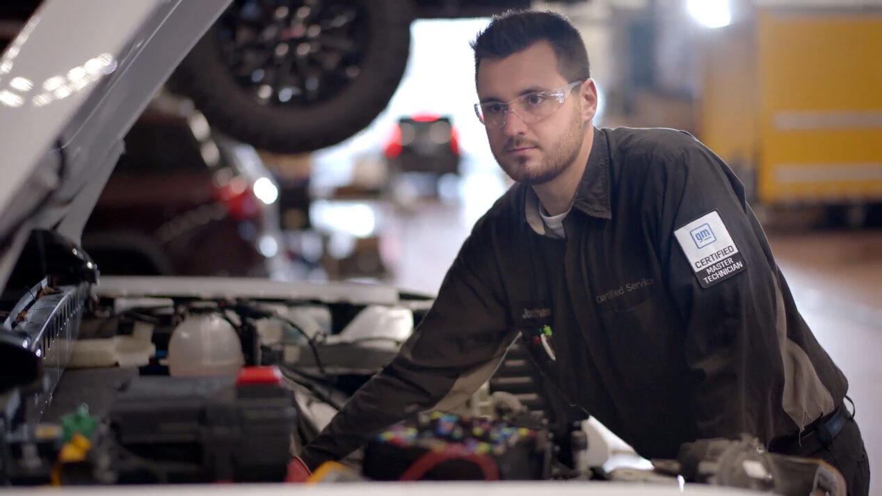 GM Technician Jonathan Standing Next to a Vehicle