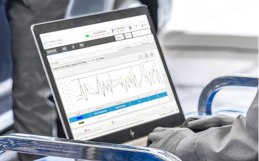 A Close-up of Hands in Black Gloves Using a Laptop with Automotive Diagnostic Software