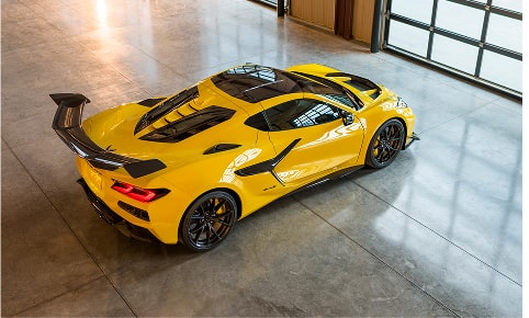 A Bright Yellow Chevrolet Corvette C8 R Sports Car Parked Indoors Viewed from Above
