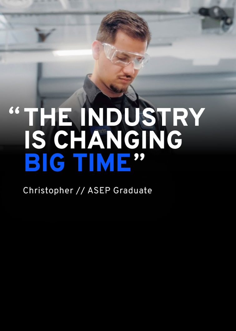 A Technician Named Chris in a General Motors Certified Service Uniform and Safety Glasses Looking Down