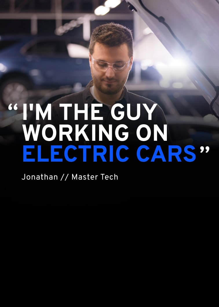 A Technician Named Jonathon in a General Motors Certified Service Uniform and Safety Glasses Looking Down