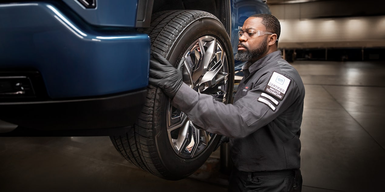 GMC Certified Service Technician Checking the Tread Level on a Tire