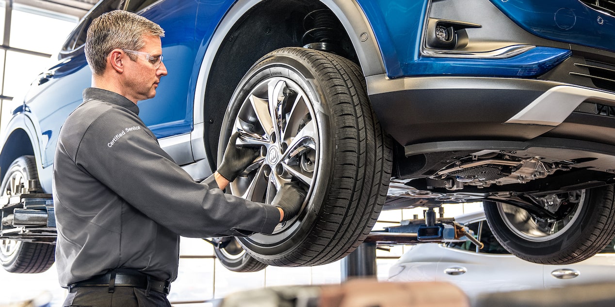 Buick Certified Service Representative Inspecting a Vehicle's Tire