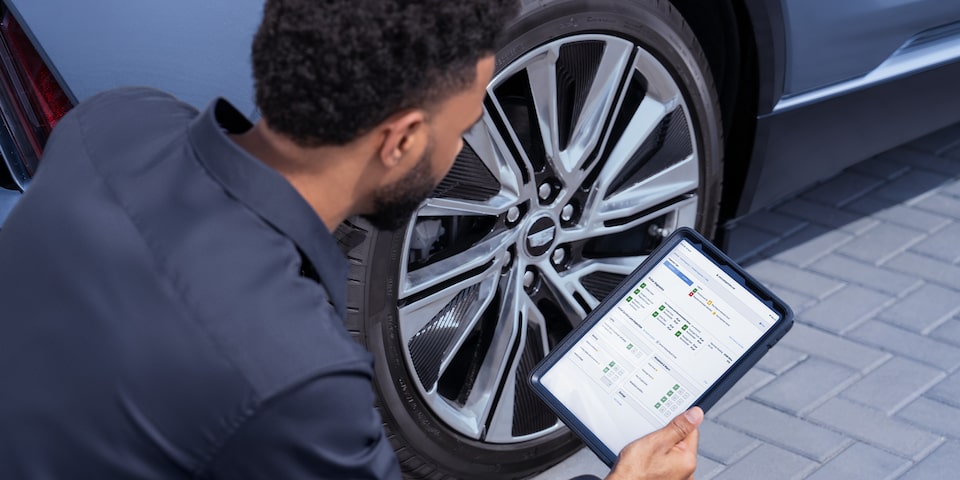 Cadillac Certified Service Technician Inspecting Vehicle Information on a Tablet