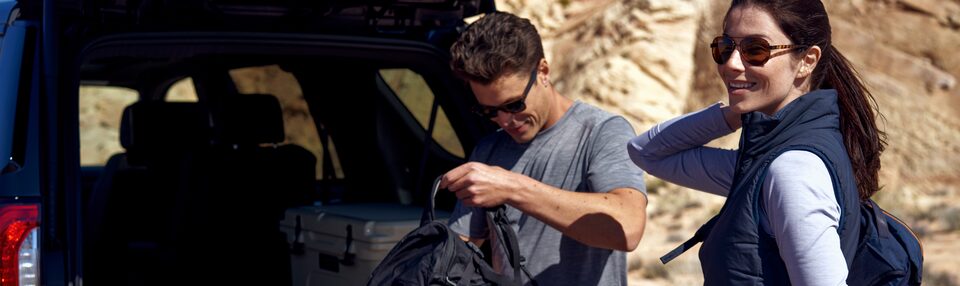 Couple Packing Hiking Gear in Trunk of GMC SUV