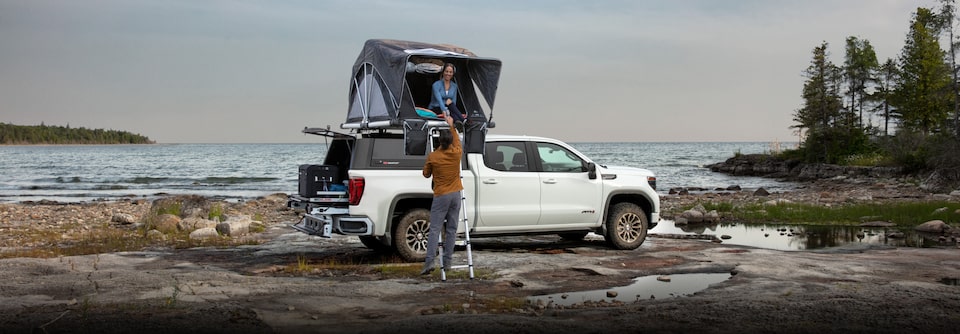 Man and women setting things up at a beach with their Chevy Silverado