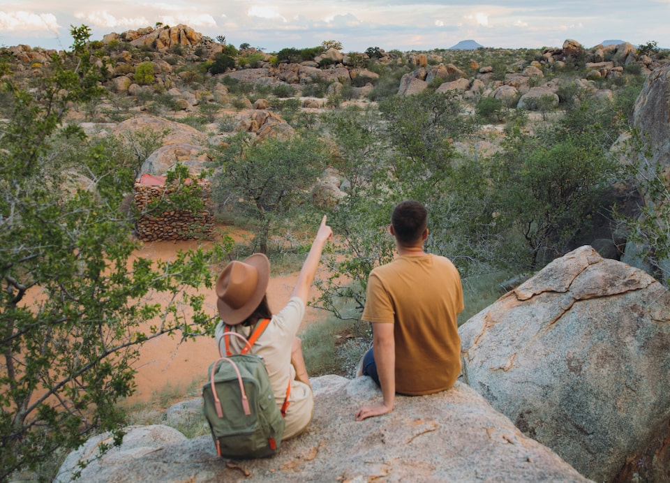 Couple sitting on a large rock while hiking