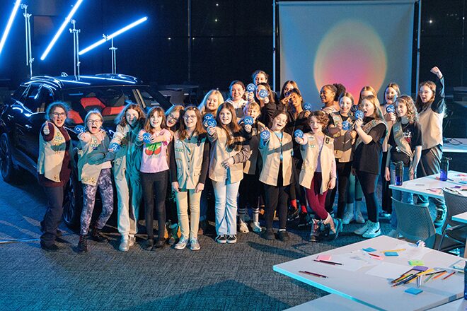 The Girl Scouts standing together for a group picture in the Next Gen Tech Lab room