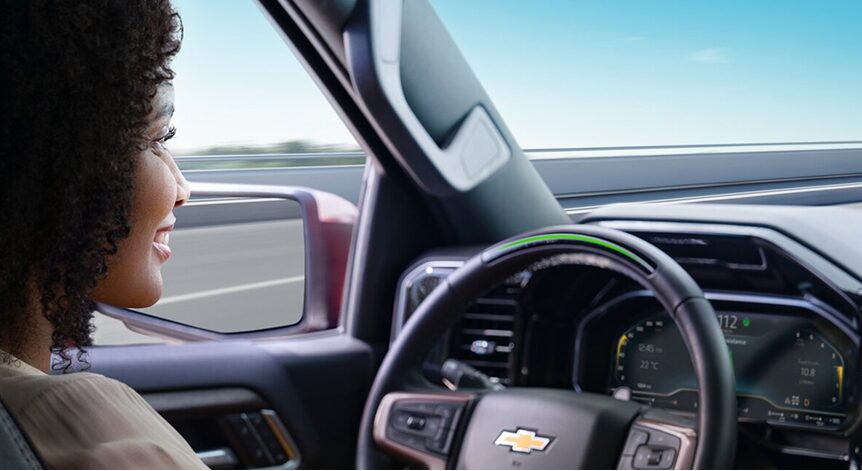 A woman sitting in the driver's seat of a Chevy