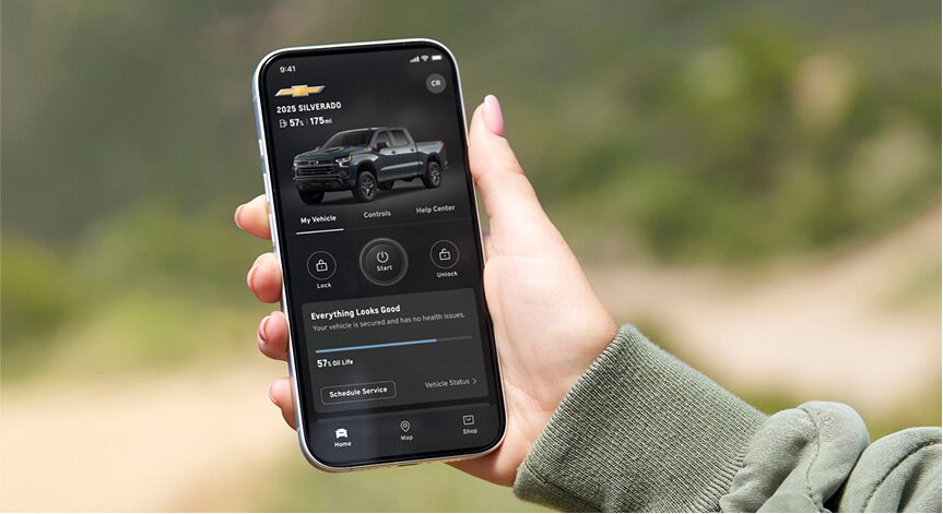 A person's right hand holding a smartphone that displays the OnStar Guardian app.