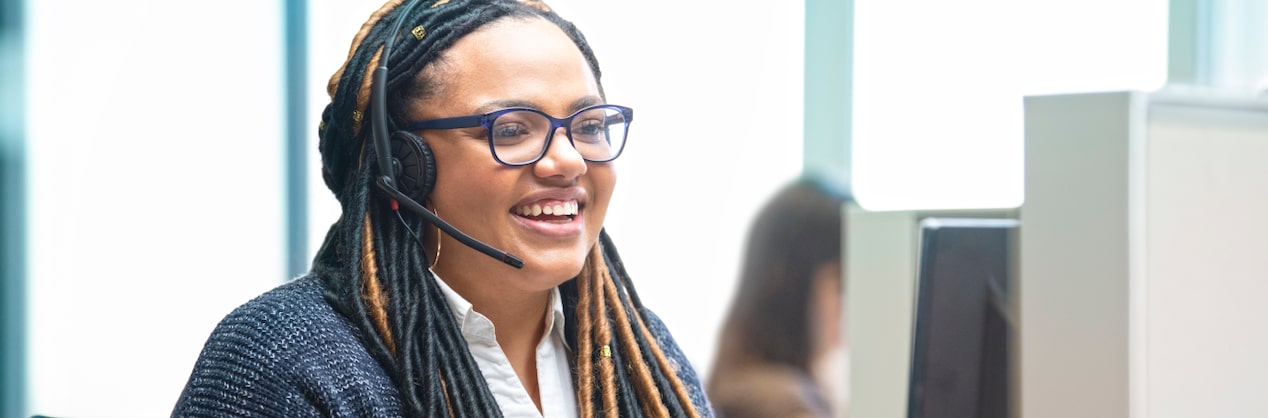 OnStar Advisor Smiling and Working on Computer