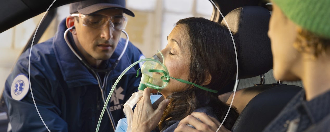 EMT Helps Woman in Passenger Seat With Oxygen Mask on