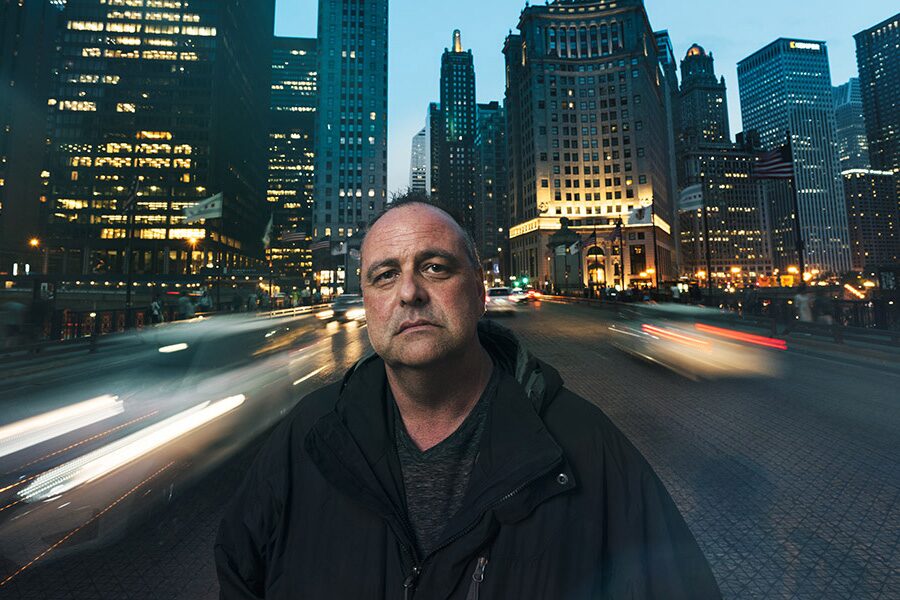 Detective Straight Faced in Front of a Large Cityscape
