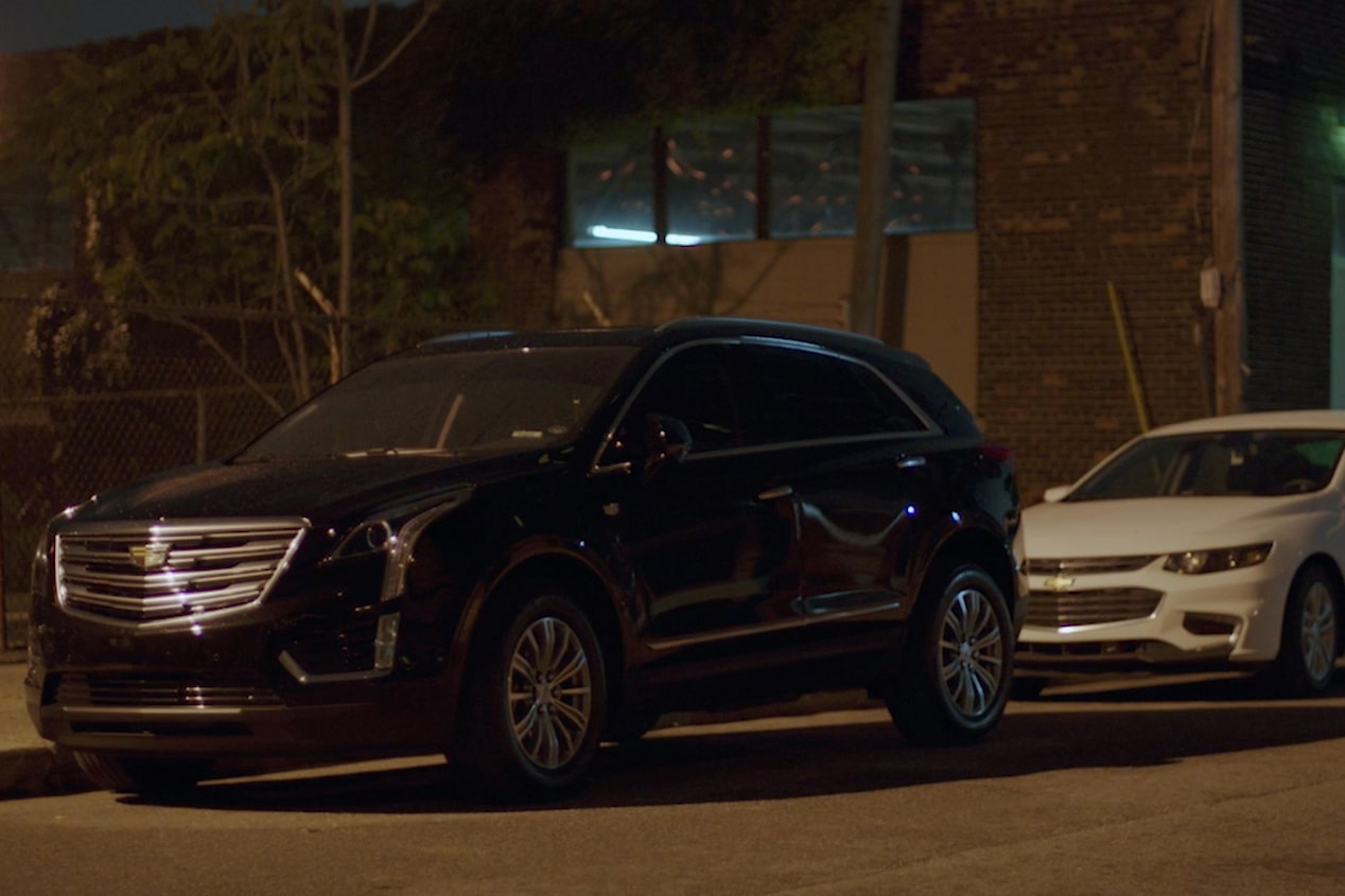 Two GM Vehicles Parked on a Dark City Street