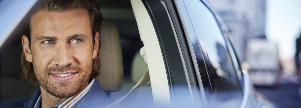 Male Driver Looking Out His Open Window With a Smirk