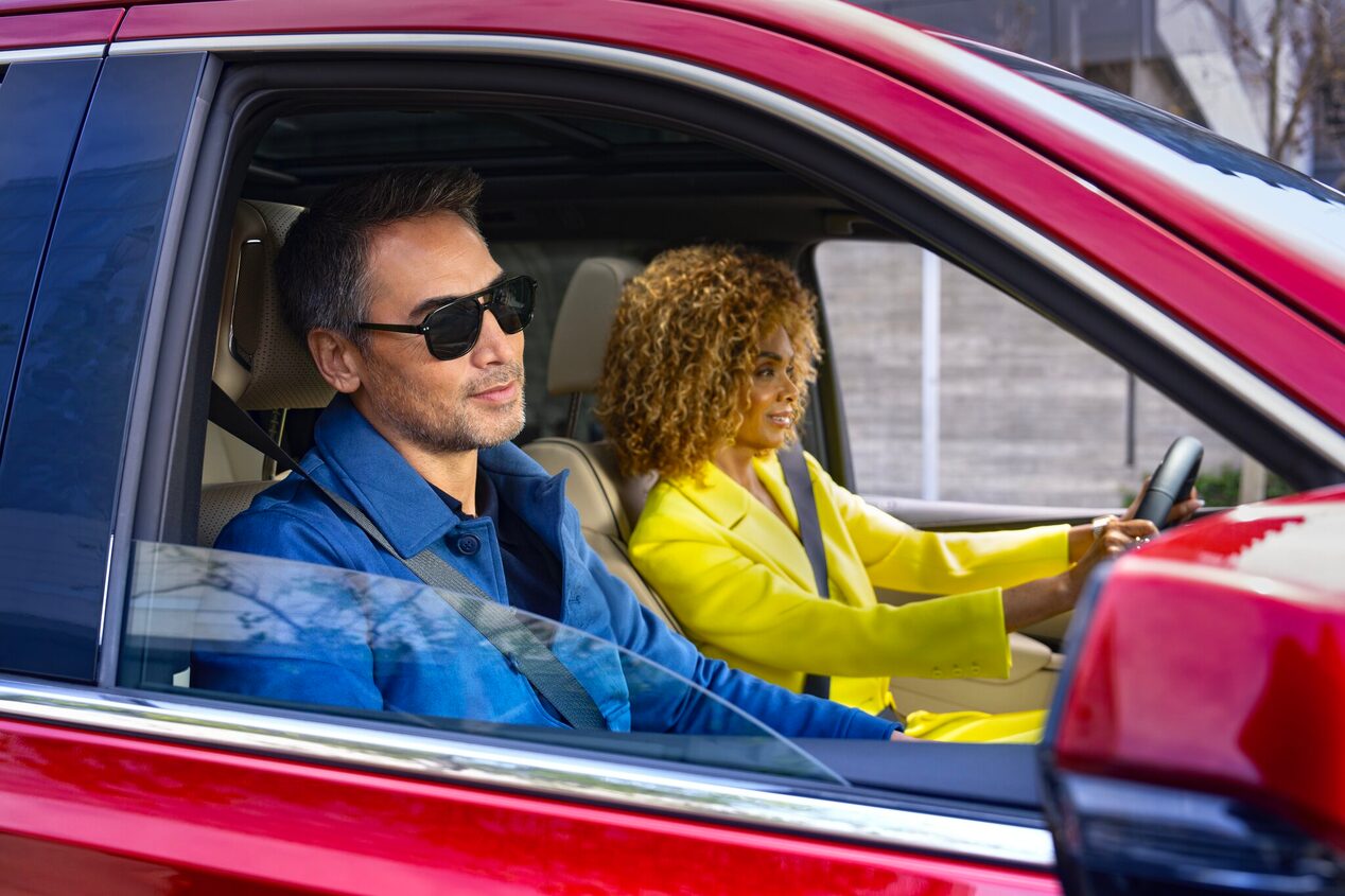 A man and woman riding in a vehicle in style