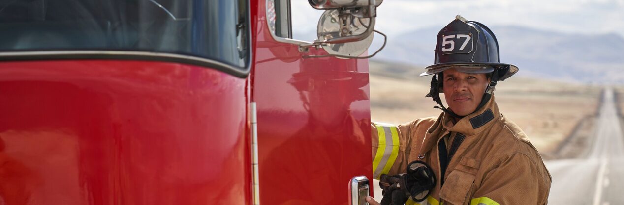 Firefighter Smiling and Entering Fire Truck in their Gear