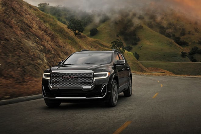 An SUV driving away from a wildfire
