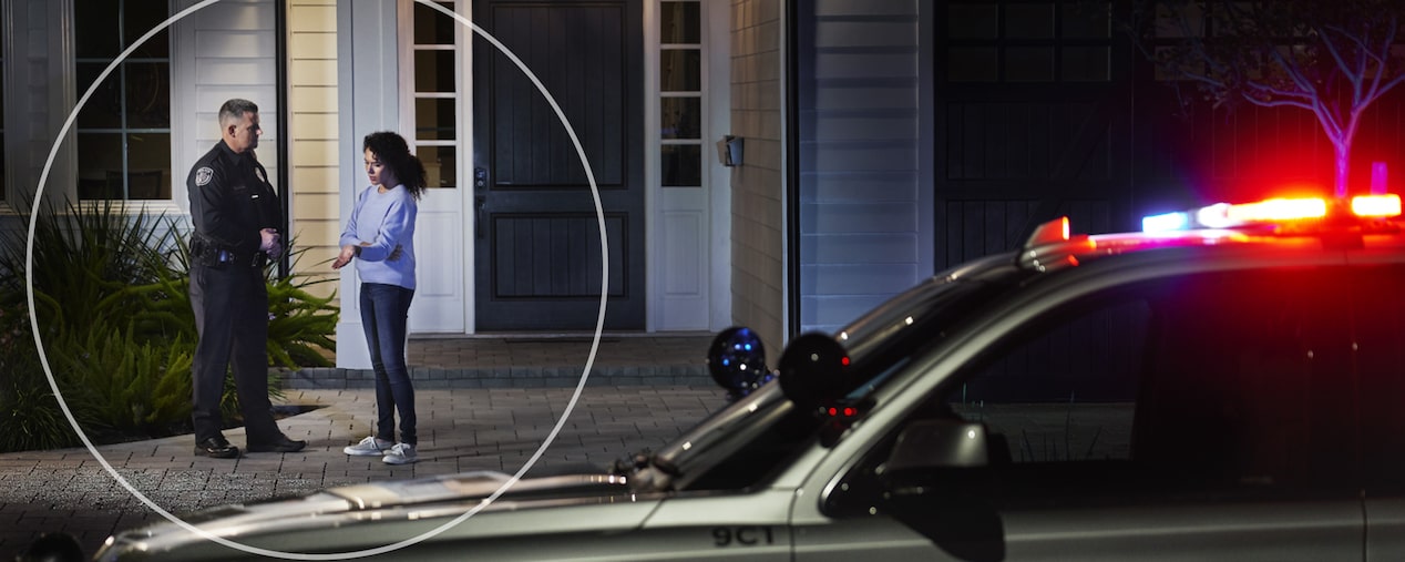 A Police Officer Talking to a Woman on her Front Porch at Night