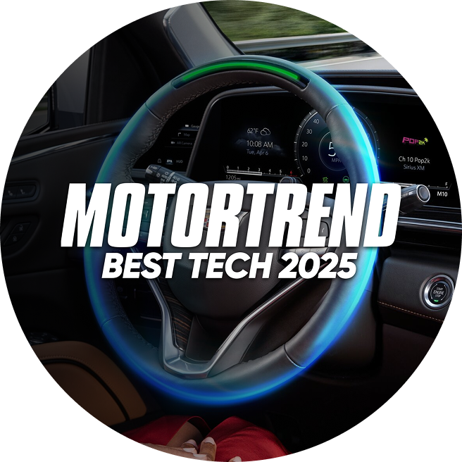 Steering wheel in a vehicle with a text overlay stating "Motortrend Best Tech 2025 Driver Assistance"