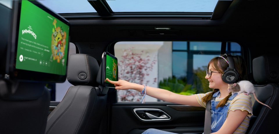 Little Girl with Pet Rat Using the Rear Seat Media System to Watch Hulu