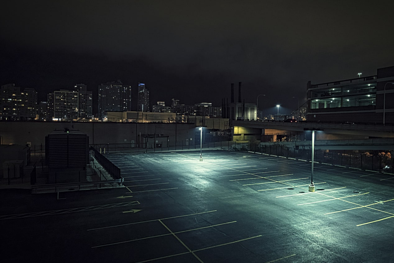 Empty and Dark Parking Lot With a Few Streetlights 