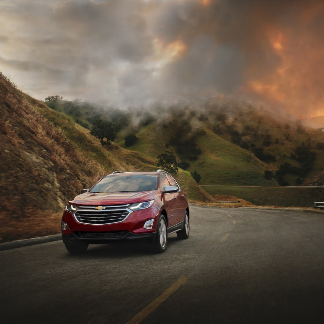 Red GM Vehicle Driving Away From Wildfire in Mountains