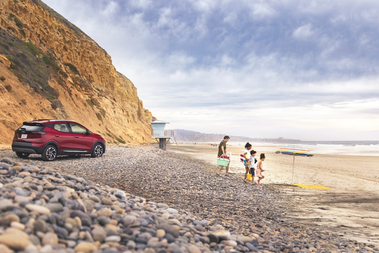 Family Playing on the Beach with Vehicle in the Background