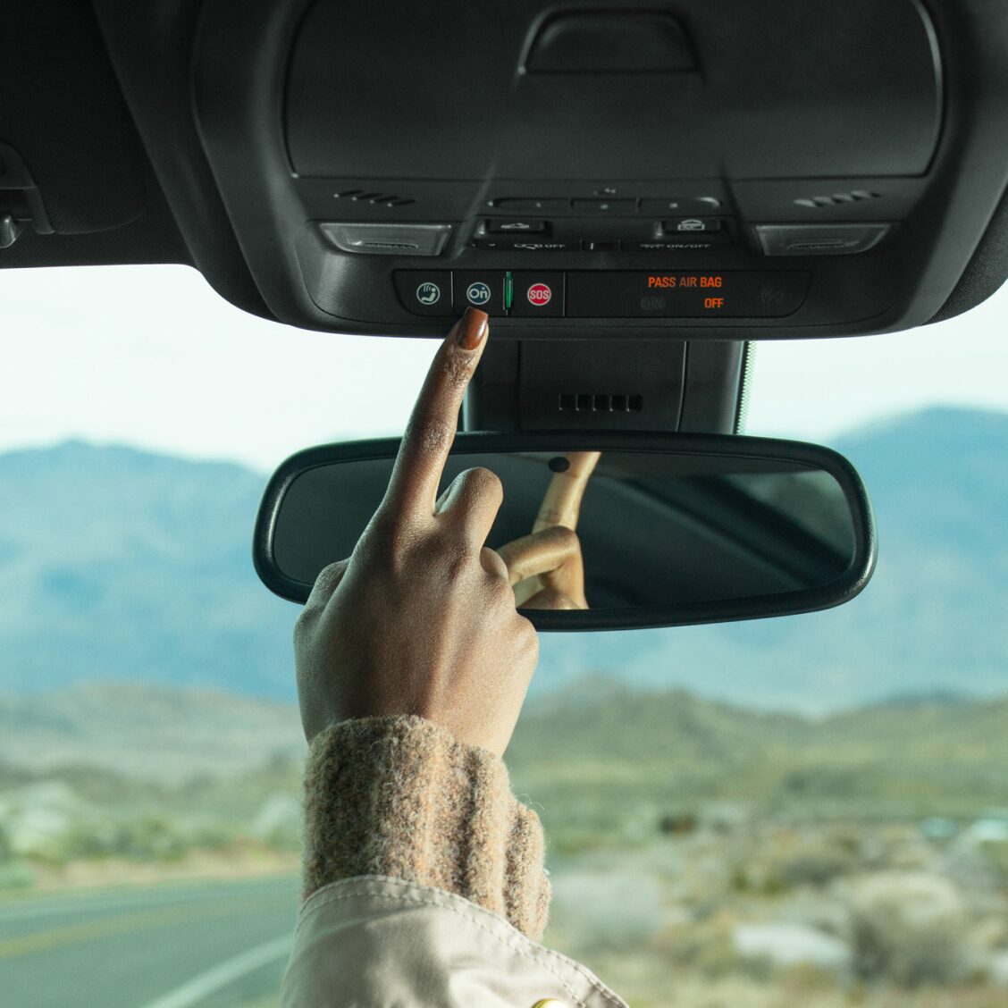 Close up of Driver Pressing the OnStar Button in Their Vehicle 