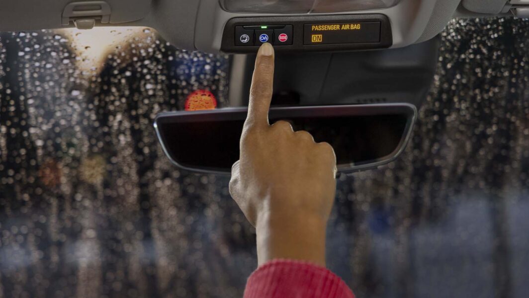 Woman pressing OnStar button with finger