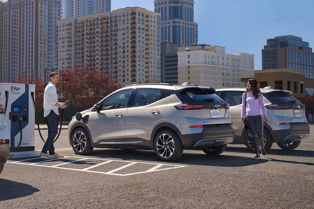 A man charging his Chevy EV at a public charging station