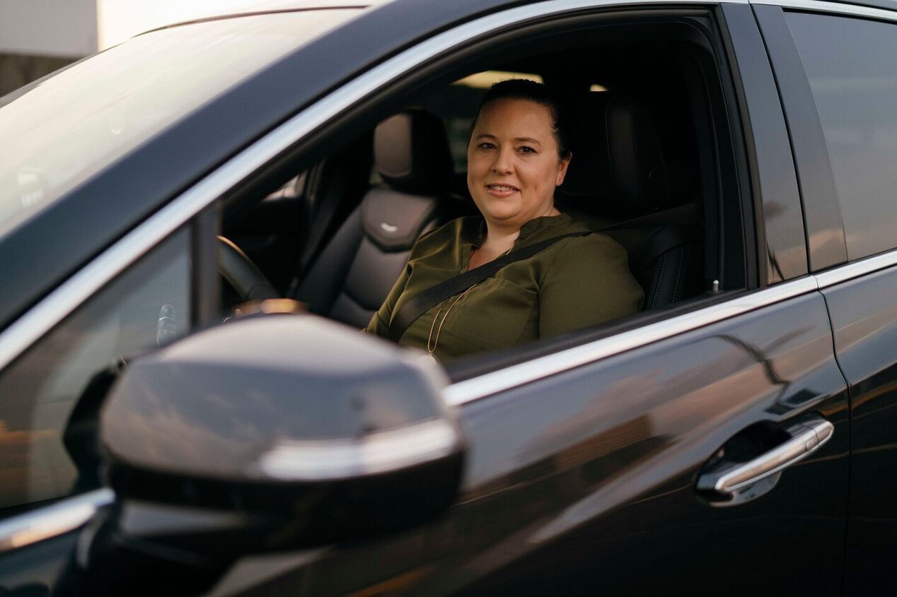 Woman in Driver's Seat of GM Truck Smiling at Camera