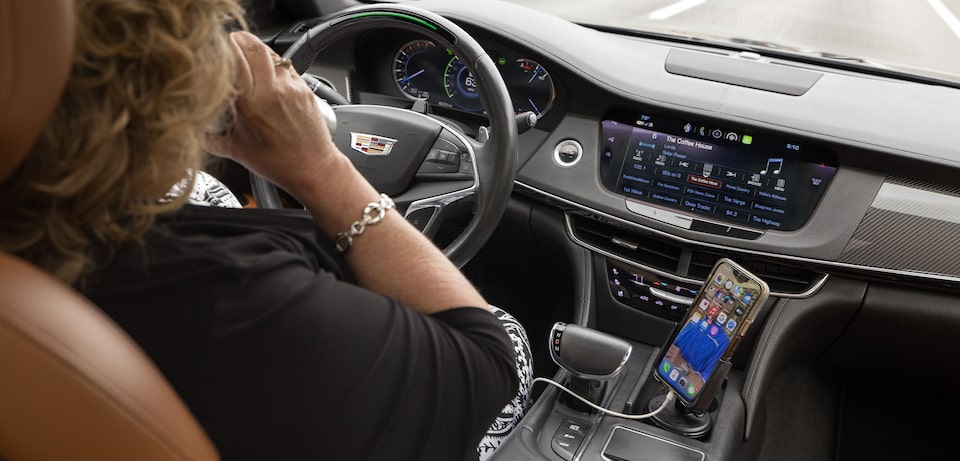 Barbara drinking coffee and using Super Cruise hands-free tech on her commute 