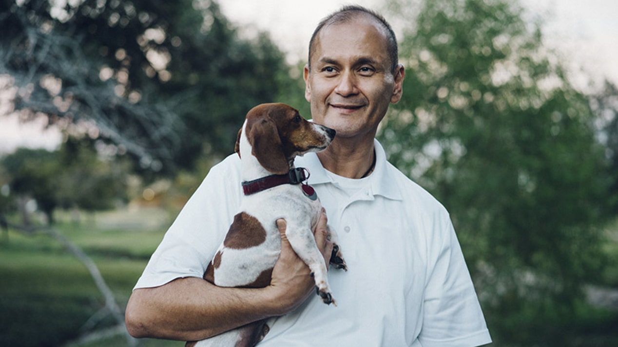 Man Smiling Holding his Dog