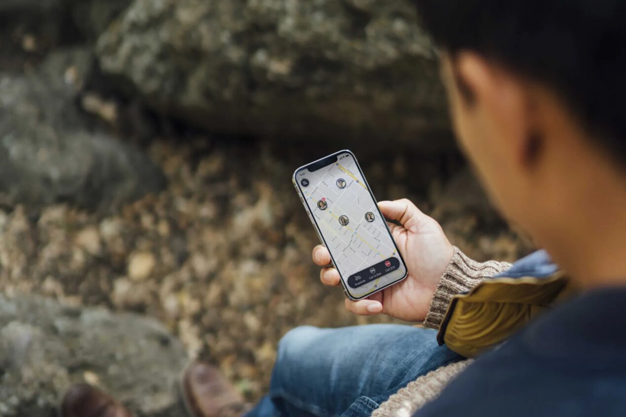 Man Looking at Smartphone Displaying OnStar Guardian App Maps