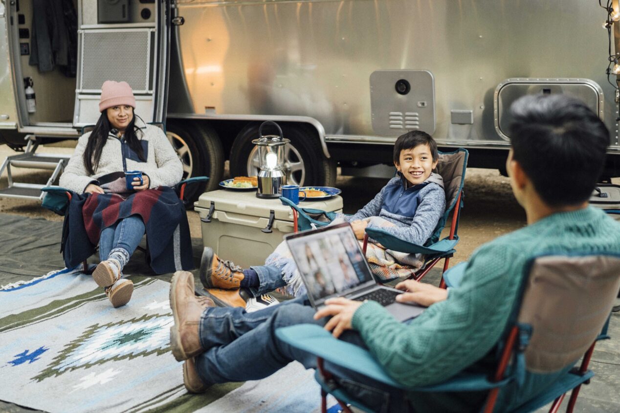 Family of Three Sitting Together Outside the Camper