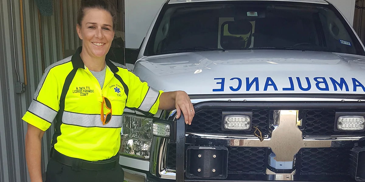 EMT Standing and Smiling in Front of Ambulance