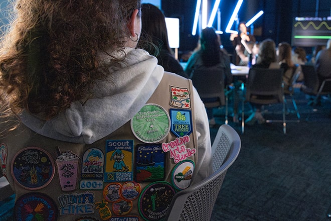 Close up of the back of a Girl Scout vest with all her collected badges