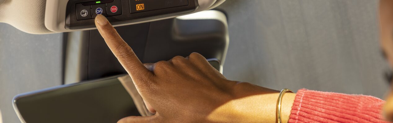 Woman Pressing OnStar Blue Button in Car
