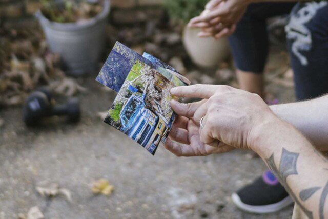 Family Showing Pictures of Hurrican Disaster