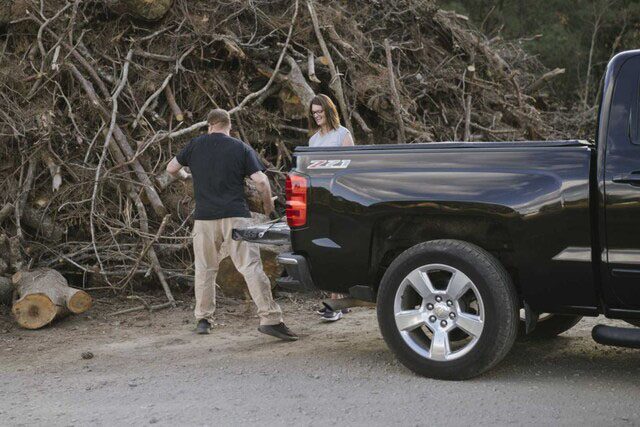 Couple Unloading Wood From Chevy Pickup Truck