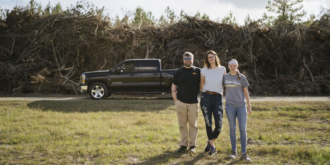 Family of Three Posing for Picture Infront of Chevy Pickup Truck 