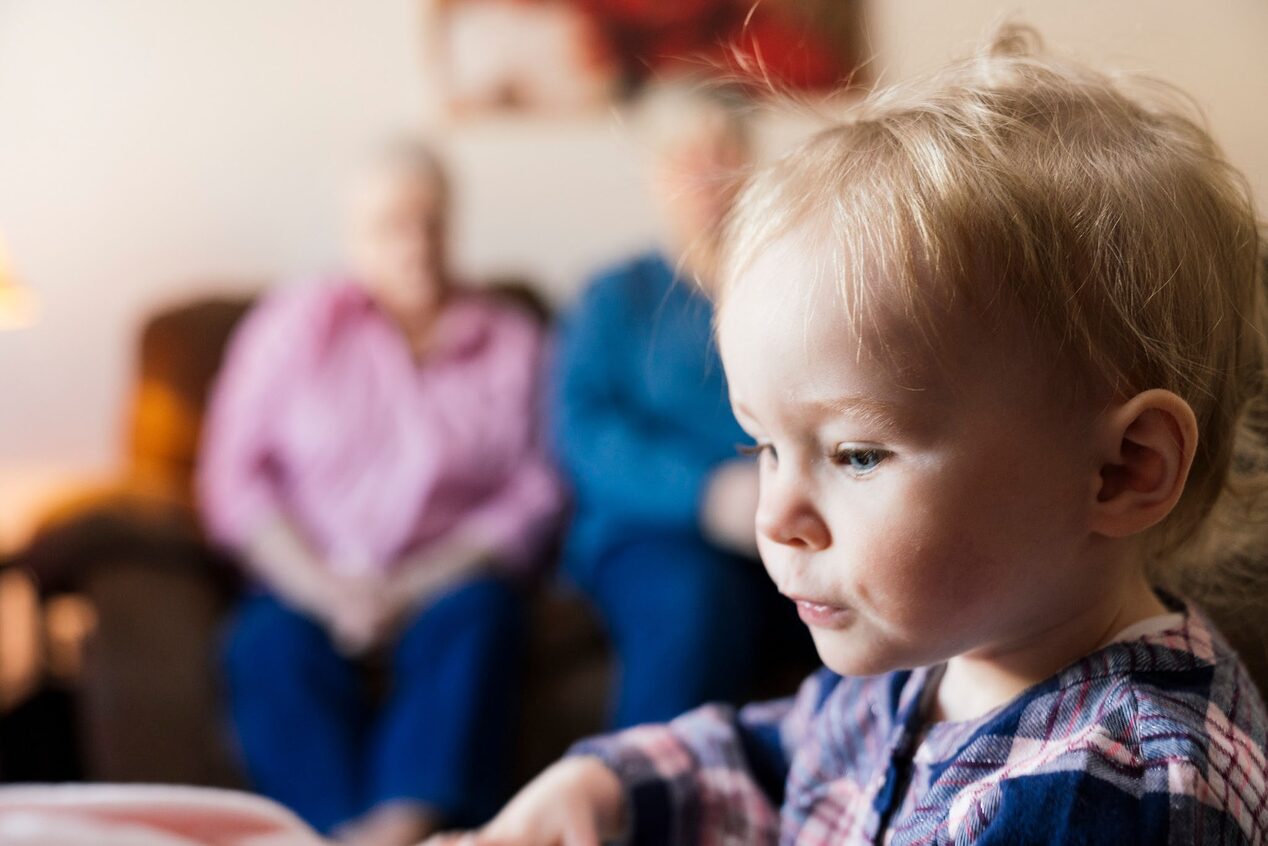 Close up of Young Girl Playing with Grandparents Sitting in the Background