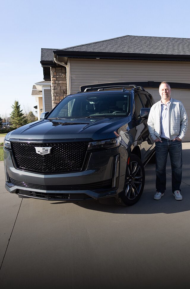 Justin smiling while standing next to his 2021 Cadillac Escalade