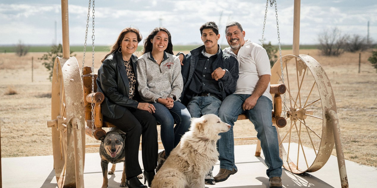 Family Sitting Together Outside with Their Dog