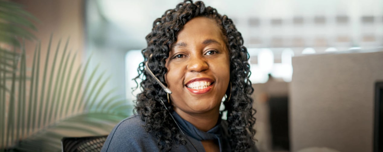 OnStar Advisor Smiling at Her Desk and Wearing a Headset