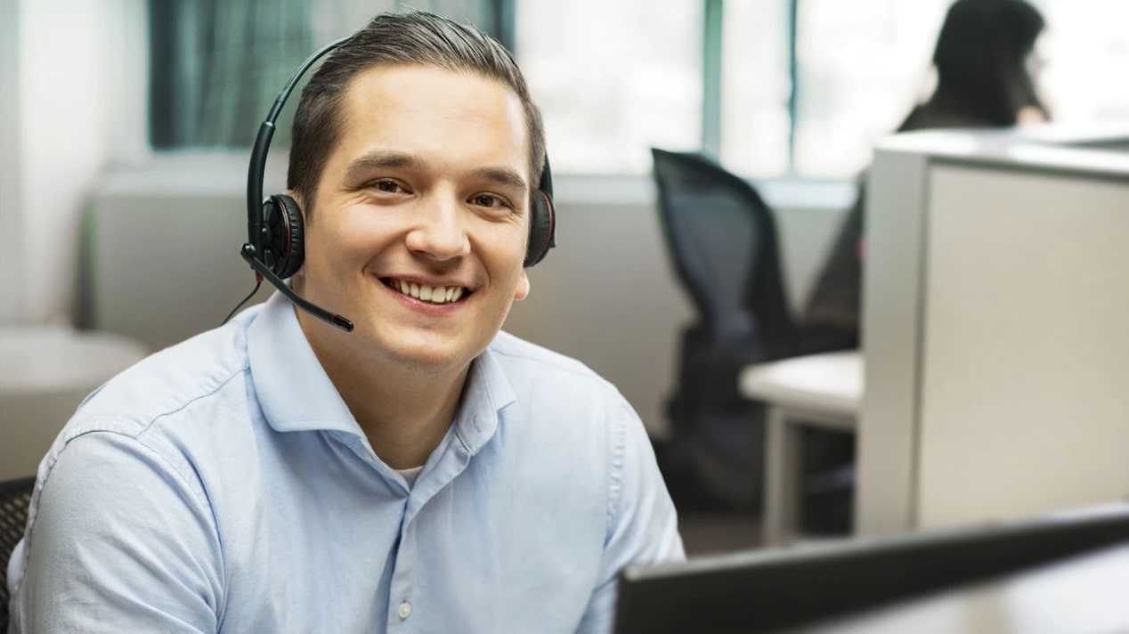 Male OnStar Advisor Wearing Light Blue Shirt Smiling at the Camera