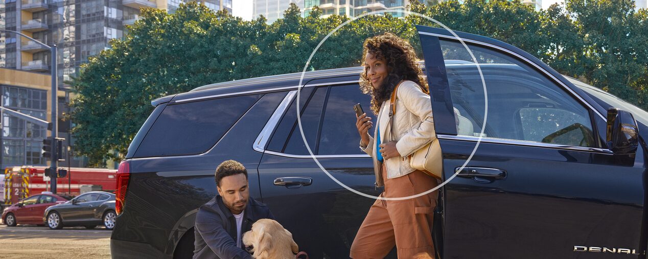 Man & Woman Standing Next to Vehicle with Their Dog