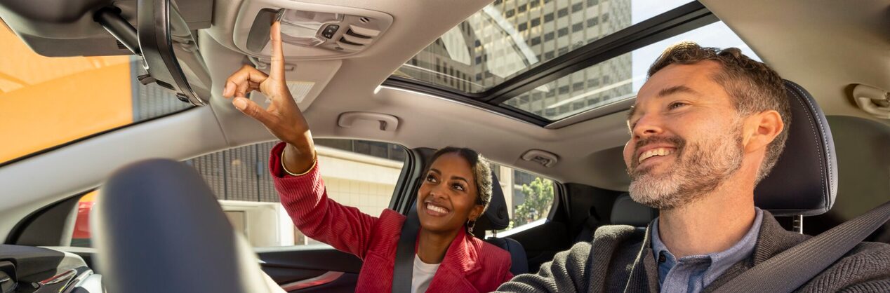 Man Smiling While Driving & Woman Smiling Pushing the OnStar Button
